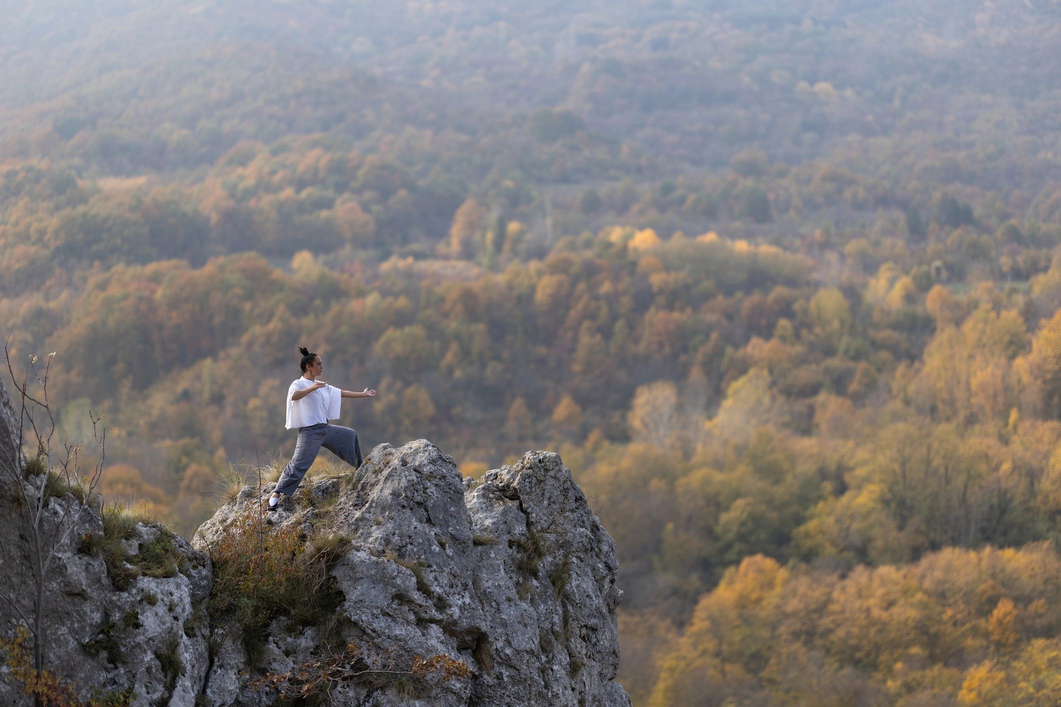 Woman practicing tai chi outdoors on a mountain