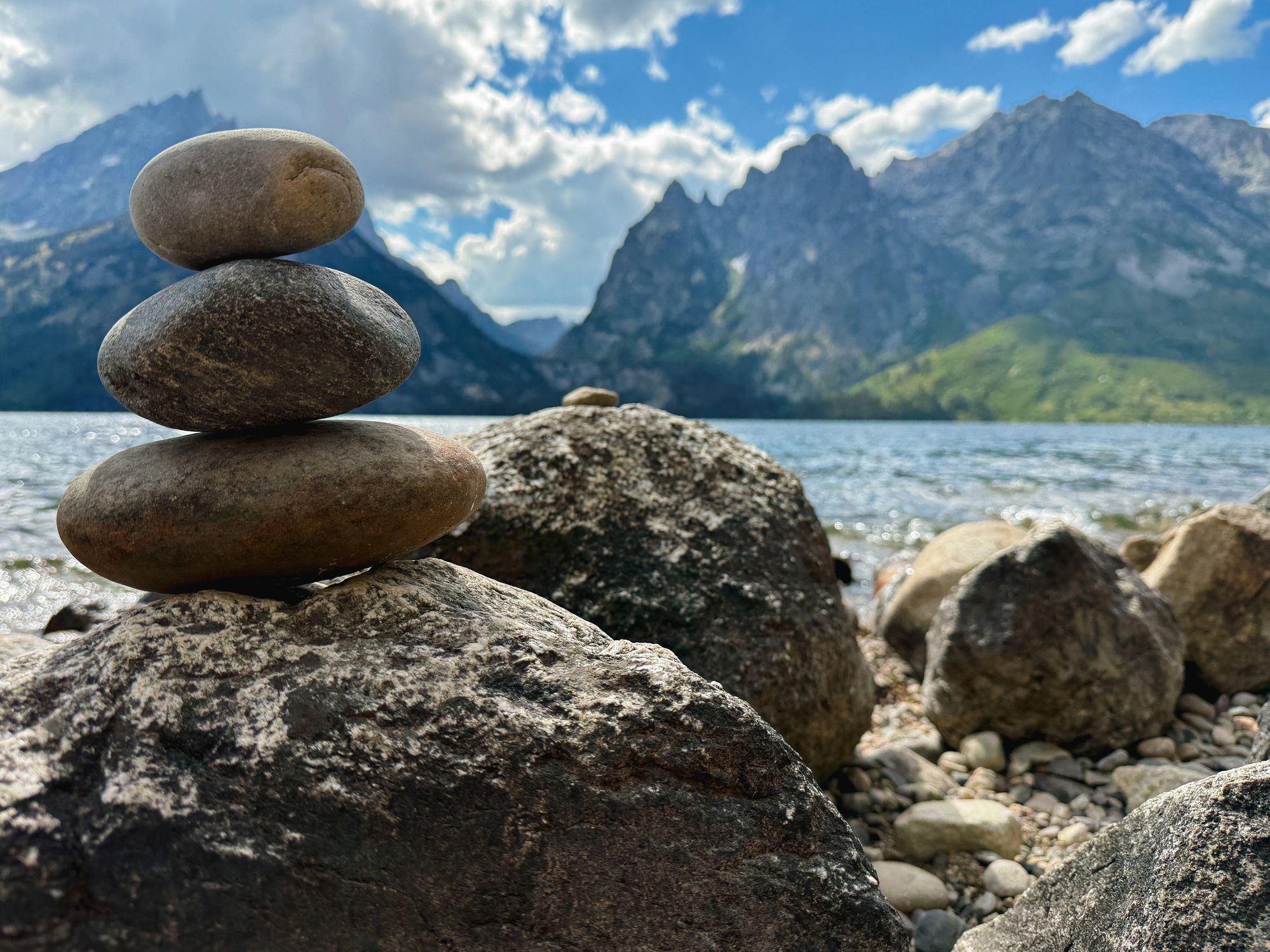 Balanced stones by a lakeshore representing calm and reflection